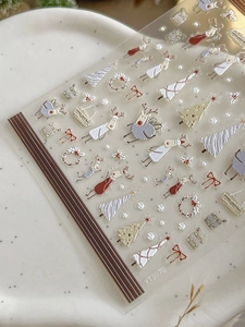 Macro shot of YT3970 Christmas nail stickers with reindeer and tree motifs on white tray
