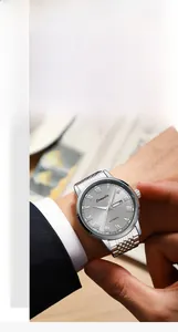 Detail of silver automatic mechanical watch with double calendar on a business model's wrist