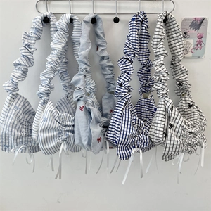 Detail view of cotton tote bags with scrunchie straps and blue stripe bow accents