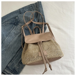 Detail of straw backpack showing woven texture and premium PU leather flap on denim jacket