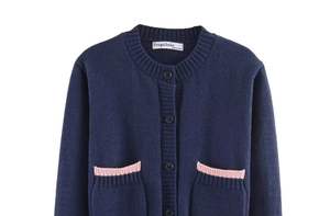 Détail du cardigan en tricot bleu marine avec bordure rose et texture maille côtelée