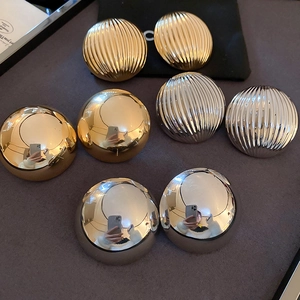 Gold and silver textured round stud earrings set with smooth and striped metal finishes