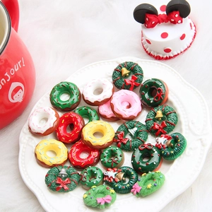 Christmas wreath and donut resin accessories for DIY crafts displayed on a white plate