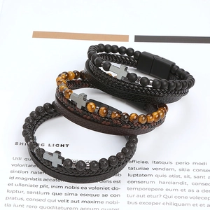 Detail of men's beaded bracelet set featuring tiger eye, lava stones and leather cross