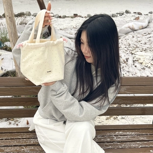 Detail of a polka dot canvas drawstring handbag with pink rope on snowy background