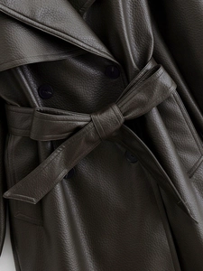 Détail de la taille d'un trench-coat en similicuir marron foncé avec ceinture et grain