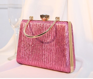 Detail of pink pleated clutch bag with gold handle and sparkling crystal clasp closure