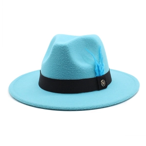 Détail du chapeau fedora en laine bleue avec ruban noir, plume bleue et boucle dorée