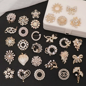 Detail showing various elegant gold and silver brooches with pearls and rhinestones