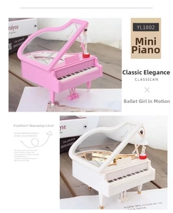 Close-up of pink and white piano music boxes with rotating ballerina figures on top