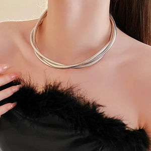 Détail du collier serpent argenté multicouche porté élégamment sur le cou du mannequin