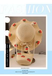 Close-up of children straw hat and mini bag set with red cherry embroidery detail