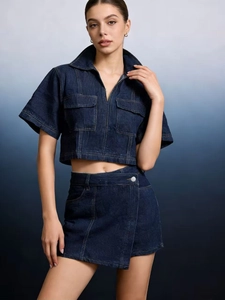 Detail of dark blue denim utility set with cropped jacket and irregular mini skirt