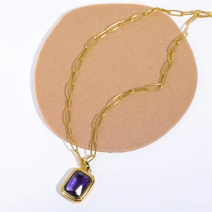 Detail of 18K gold paperclip chain necklace with a purple emerald-cut zircon pendant