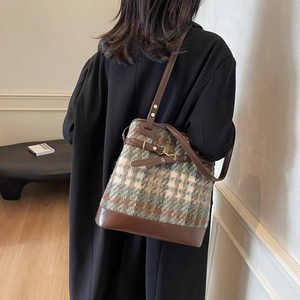 Retro plaid wool bucket bag with brown leather trim and golden buckle on model