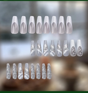 Détail de faux ongles de Noël argentés à paillettes avec motifs flocons et strass élégants