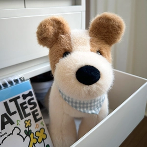 Plush Fox Terrier stuffed animal toy with blue checkered scarf in cozy room setting