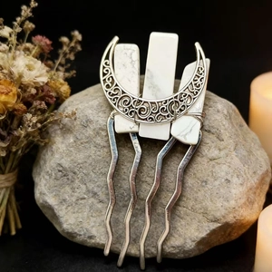 Detail of moon-shaped bridal hair comb with natural white crystals on stone background