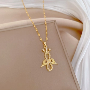 Gold angel wing and infinity necklace with sparkling rhinestones on soft beige background