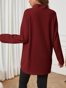 Back view of a burgundy fleece maternity top with a loose long sleeve fit in cozy room