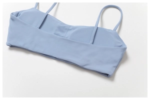 Detail eines hellblauen Sport-BHs mit dünnen Trägern und feiner Naht am Rücken