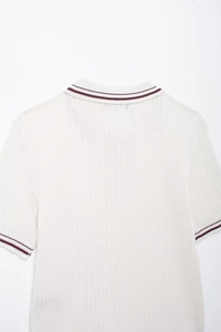 Detail of white rib-knit polo shirt back with burgundy stripes on collar and cuffs