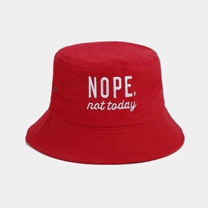 Close-up of red cotton bucket hat with white NOPE not today embroidery and metal eyelets