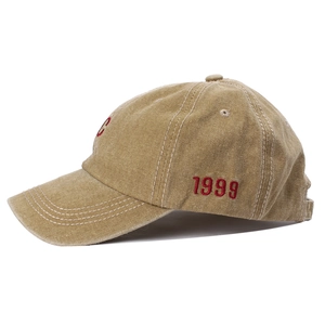 Dettaglio del ricamo C rosso e testo 1999 sul cappellino in cotone kaki lavato