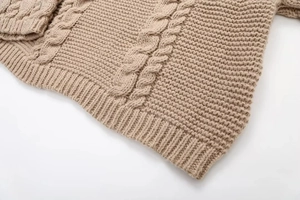 Detailed macro shot of khaki cable knit sweater texture and ribbed hem craftsmanship