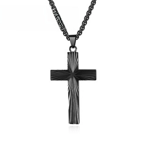 Macro shot of black stainless steel cross necklace with radial sunburst texture details