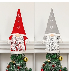 Close-up of red and grey knitted Christmas gnome tree toppers with snowflake patterns