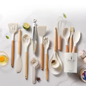 Close-up of 14-piece silicone kitchen utensil set with wooden handles on marble surface