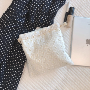 Detailed view of floral lace embroidery and drawstring closure on cotton storage bag