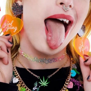Chunky orange heart earrings with 'girl gang' text on model with rainbow lace choker