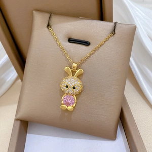 Nahaufnahme der goldenen Hasen-Halskette mit rosa Edelstein und glitzernden Zirkonien
