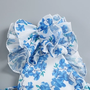 Detailed close-up of blue floral print on white chiffon fabric with layered ruffles