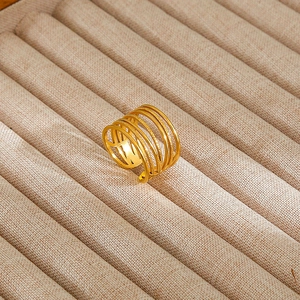 Detailed close-up of a layered gold-plated 925 silver ring on a textured display