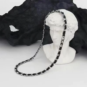 Detail of a braided black and silver metal chain necklace worn on a white David bust statue