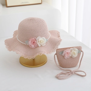 Close-up of pink straw sun hat and matching bag with fabric roses and pearls