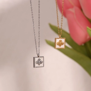 Close-up of gold and silver square mother-of-pearl necklaces with bee relief pendant