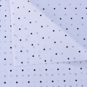 Detail of translucent white wrapping paper featuring black polka dots and thin texture
