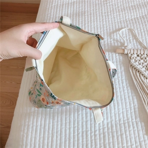 Close-up of floral cotton tote bag showing zipper closure and beige fabric lining interior