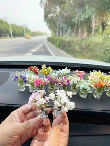 Close-up of mini glass wishing flower vases with Good Luck labels for car dashboards