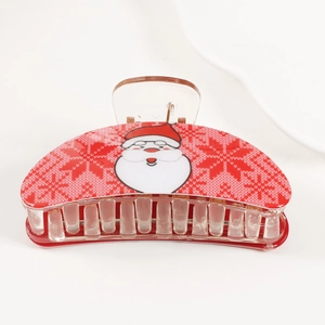 Detailed view of red Christmas hair claw clip with Santa and snowflake patterns