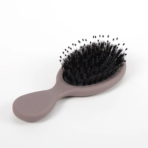 Beige boar bristle air cushion hairbrush with nylon pins on white background