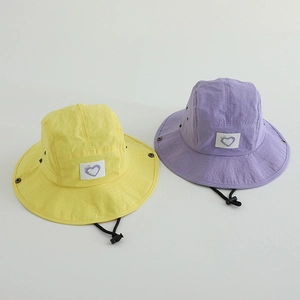 Detail of quick-dry sun hats with adjustable wind ropes and heart pattern in yellow and purple