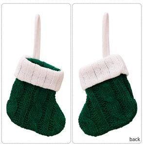 Detailed close-up of green cable-knit mini Christmas socks with white ribbed cuffs