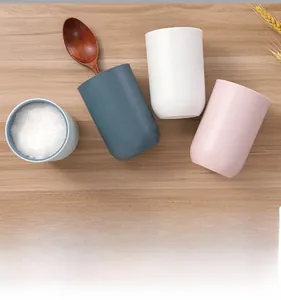 Versatile two-tone mouthwash cups used as breakfast mugs on a rustic wooden table
