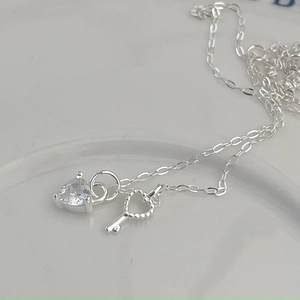 Close-up of 925 sterling silver O-chain necklace with zircon heart and key pendants