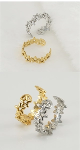 Detail view of adjustable star-shaped steel rings in polished gold and silver finishes